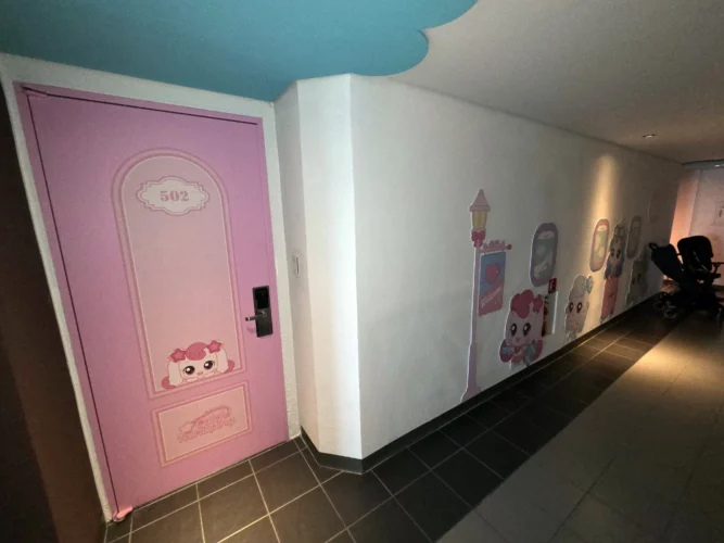 한화리조트 용인 티니핑 객실 502호의 분홍색 출입문과 복도 장식